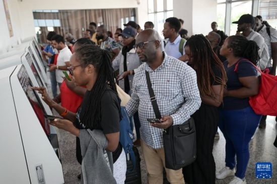 5月31日，在蒙內(nèi)鐵路內(nèi)羅畢站，乘客在自助取票機(jī)前排隊(duì)取票。新華社記者 楊光 攝