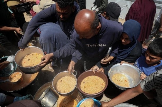 5月28日，人們在加沙城西部的沙提難民營領(lǐng)取救助食物。新華社發(fā)（里澤克·阿卜杜勒賈瓦德攝）